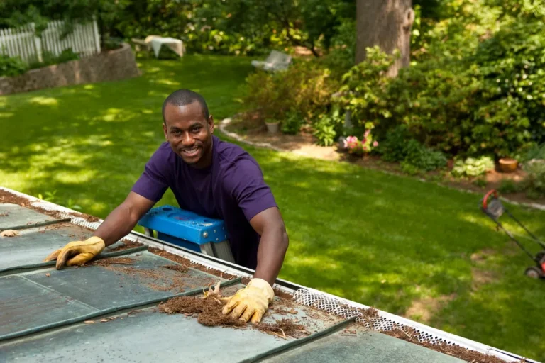 Man clearing debris from a gutter with leaf protection